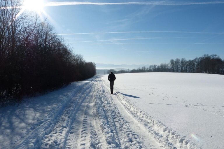 A man walking alone in a winter landscape. Light exposure can reduce symptoms of winter depression