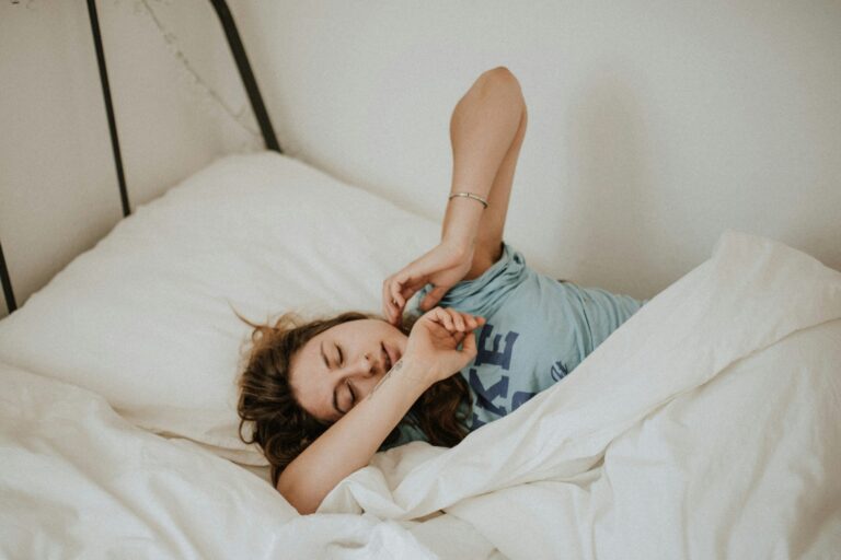 Sleepy woman suffering from sleep inertia in bed